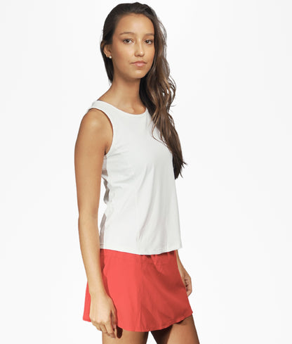 Polera Ibiza blanca combinada con short rojo, vista lateral, look deportivo para pádel y tenis